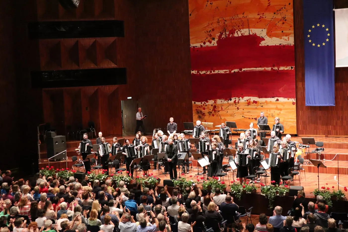 London Accordion Orchestra taking a bow in a large concert hall in Innsbruck