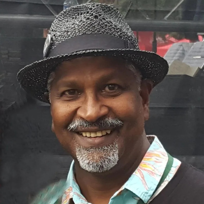 Portrait of David Kalloo wearing a trilby hat