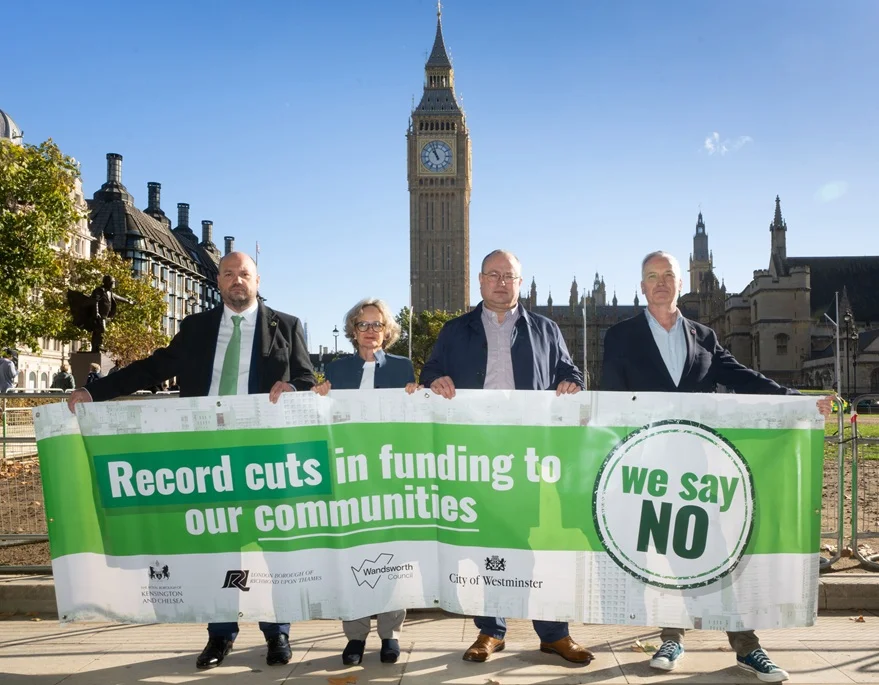 Council leaders from Kensington and Chelsea, Westminster, Wandsworth and Richmond hold a banner against funding cuts in Parliament Square