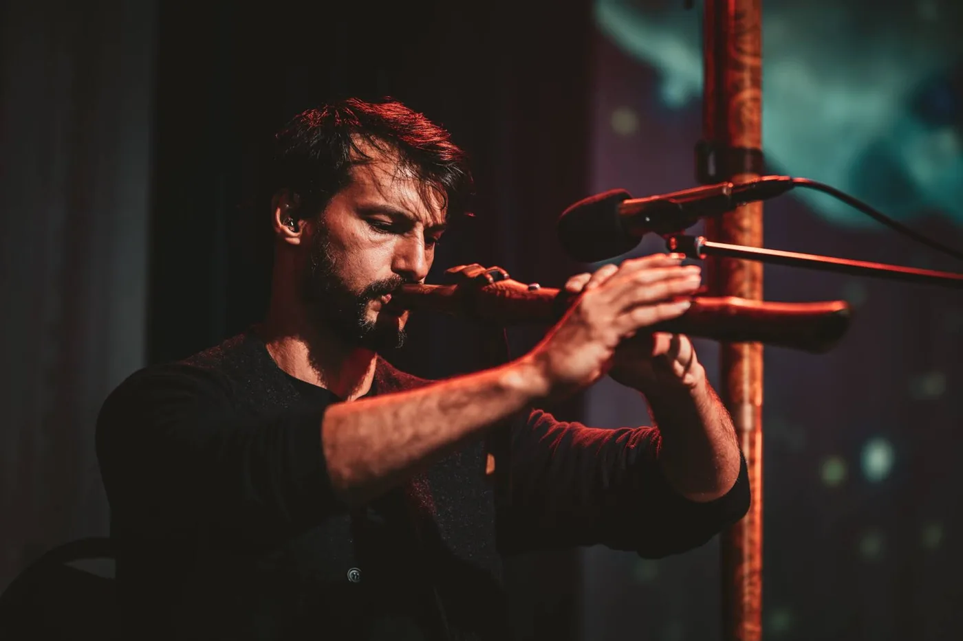 Christian Dimarco playing a long wind instrument into a microphone